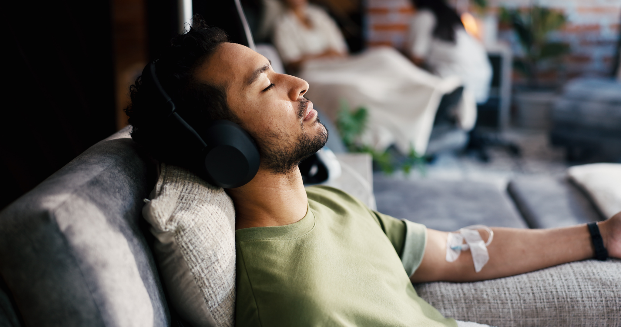 Man relaxing on a couch with headphones during a ketamine therapy session