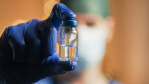 Doctor with vaccine on Christmas Background Regenerative Peptides