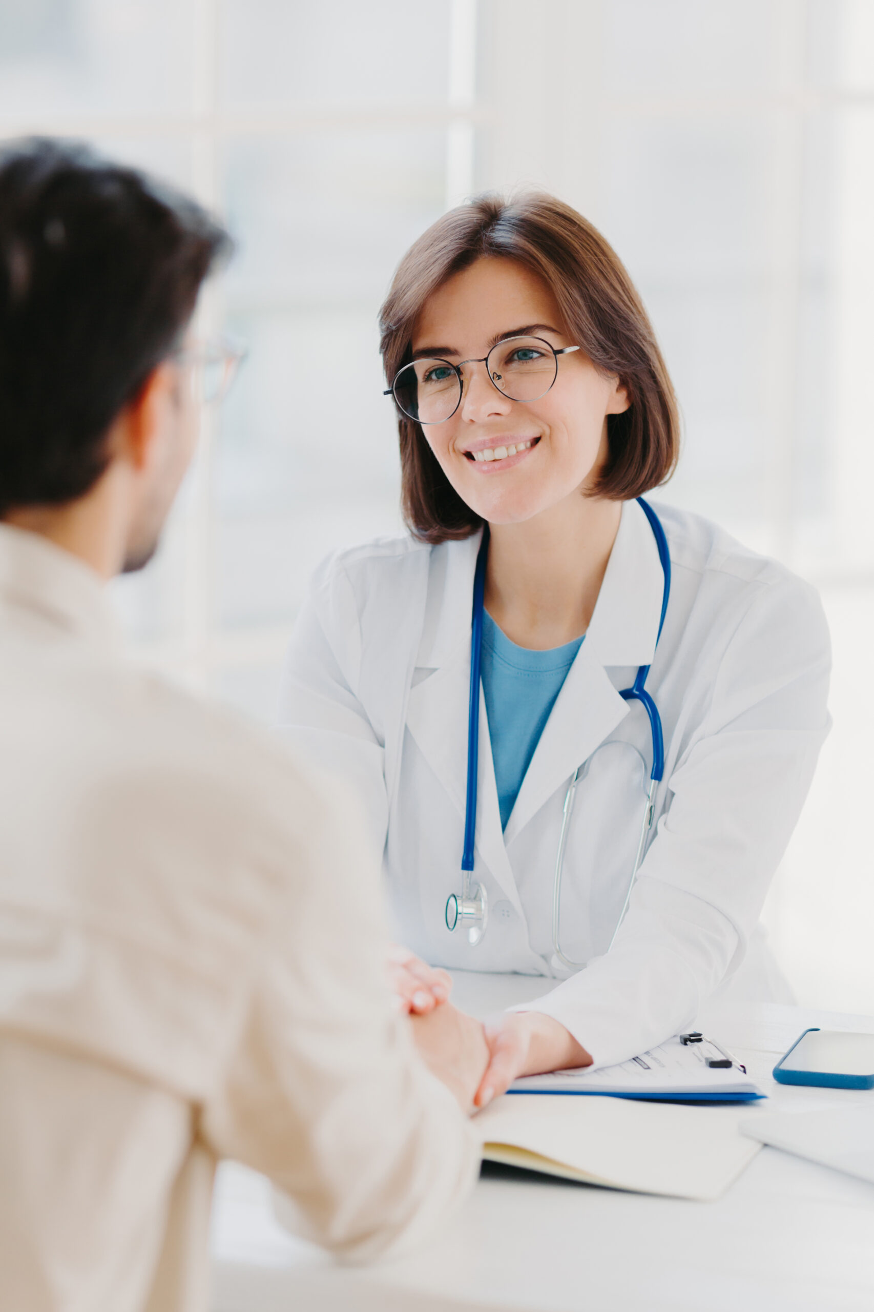 Smiling female doctor greeting a patient during a consultation