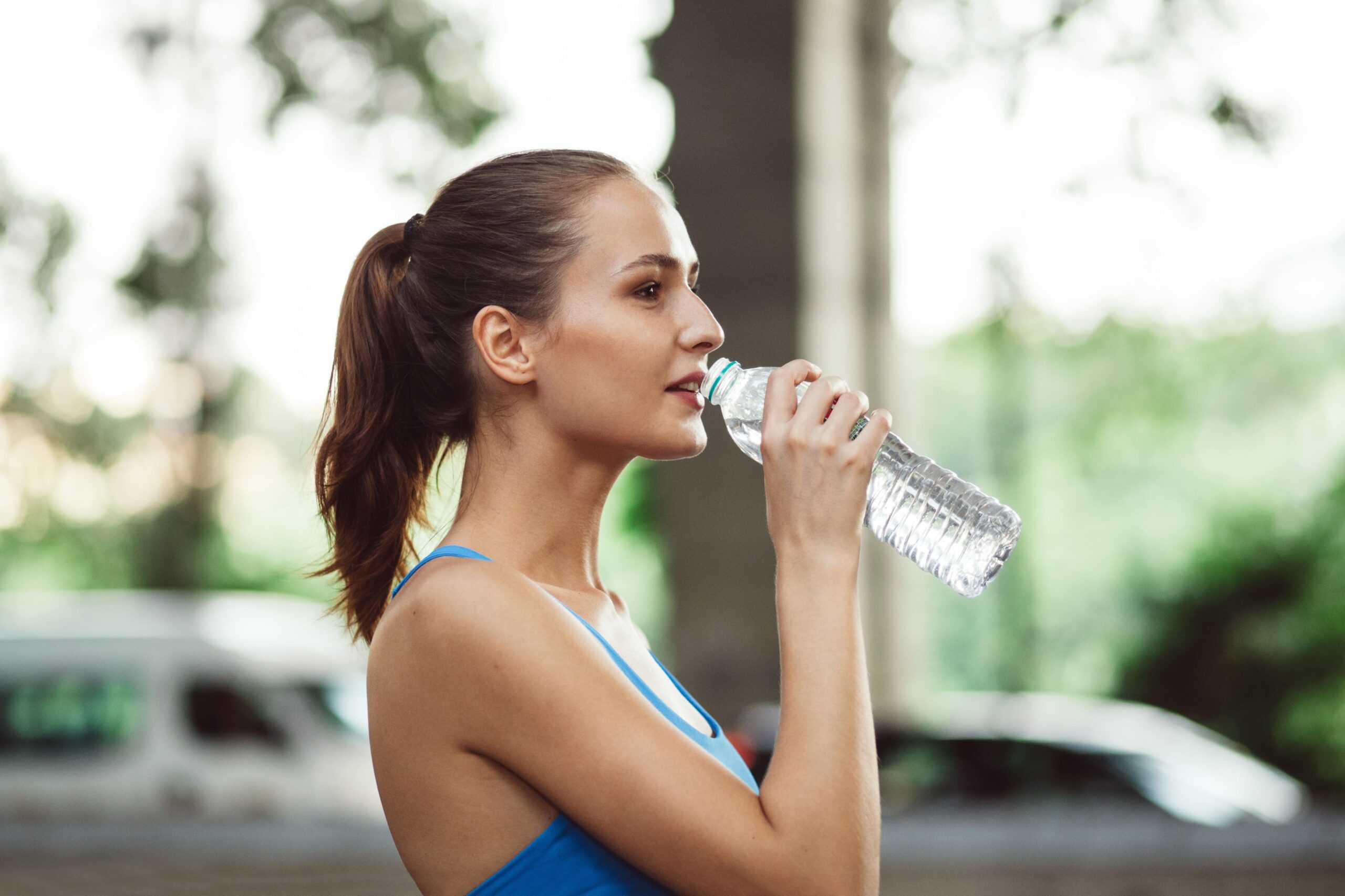 Woman drinking water to stay hydrated after physical activity