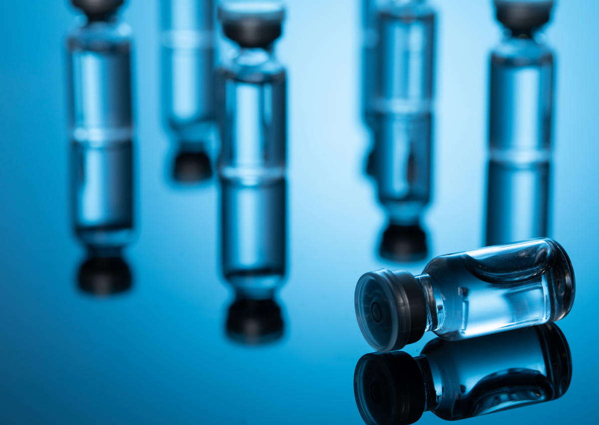 Glass vials of peptide medication on a blue background