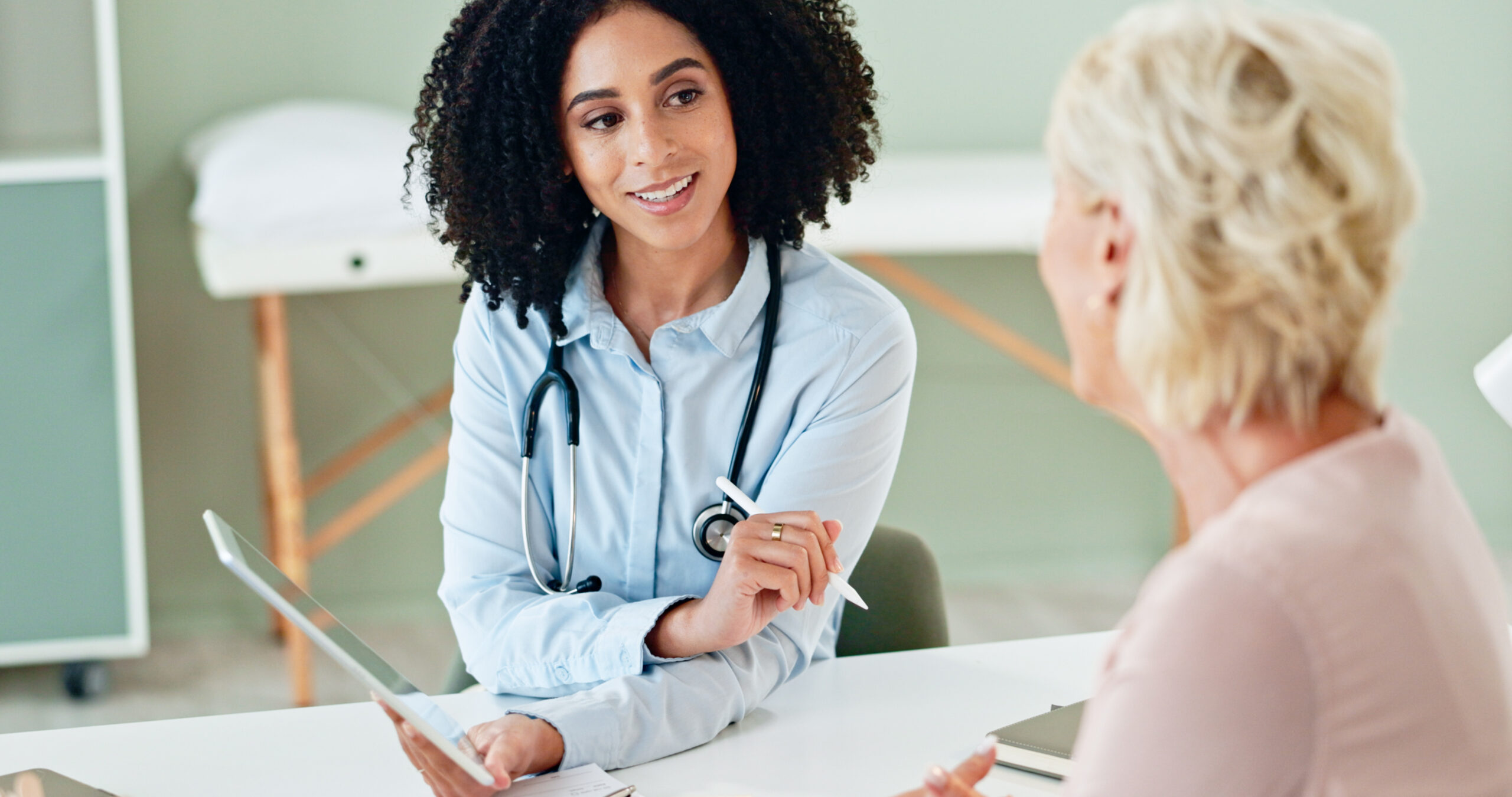 Female clinician consulting with a patient during an exam