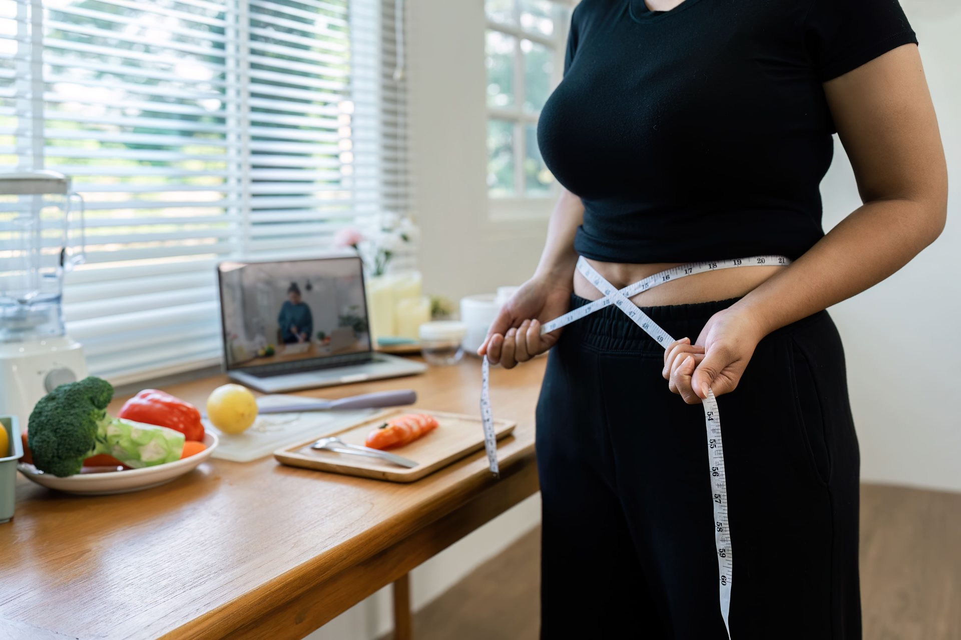 Woman measuring her hips with a tape measure during a weight loss program