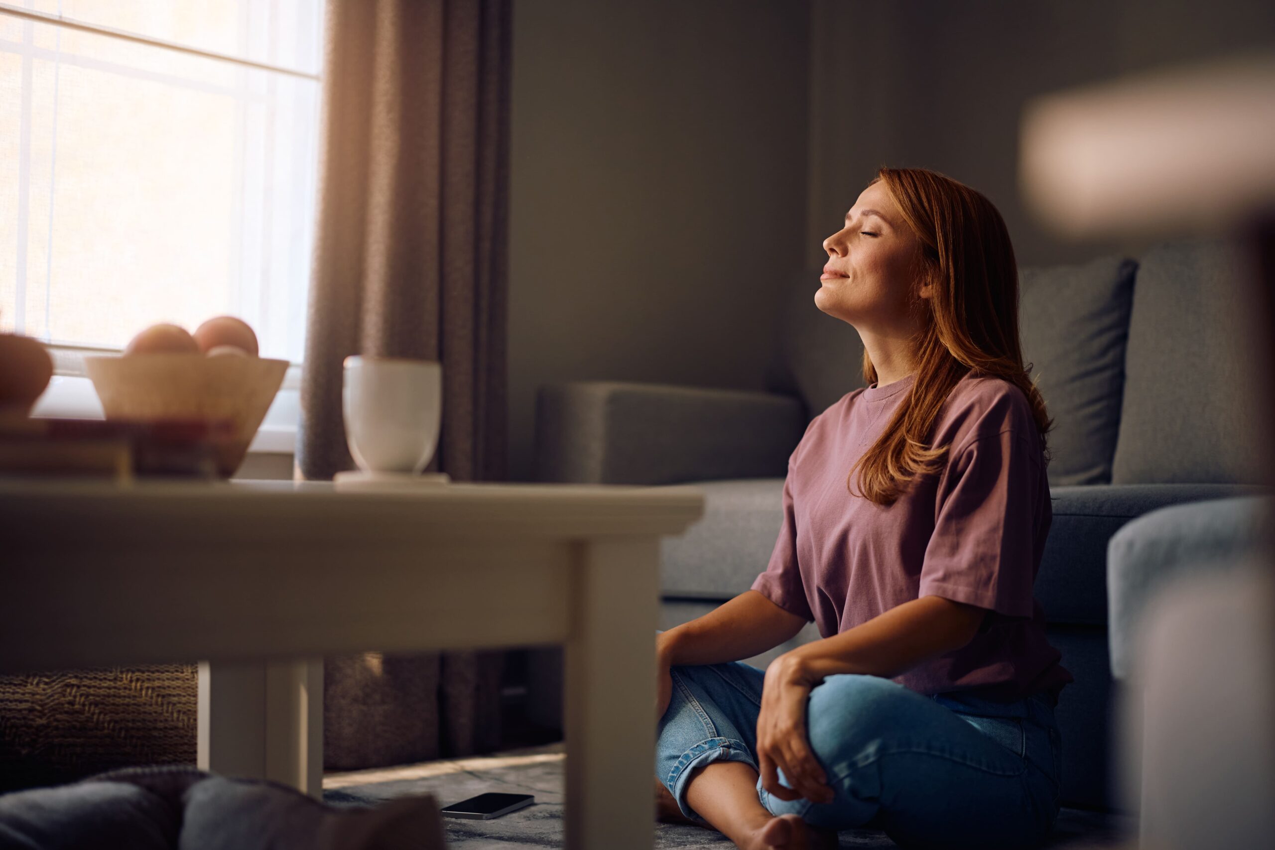 Woman meditating indoors with her eyes closed
