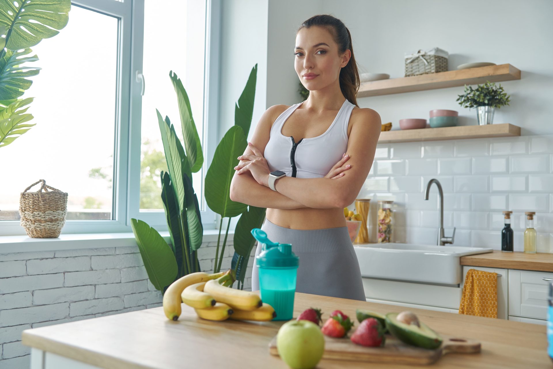 Active woman posing with healthy foods in her kitchen